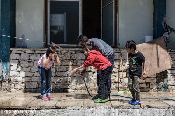 Some kids plays with water in Lavrio Camp (Greece), a camp only for kurdish refugees.